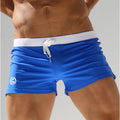 Blue low-waist swim trunks with white drawstring cord and front seam lines