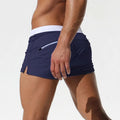 Dark blue low-waist surf trunks with white waistband and side pocket opening