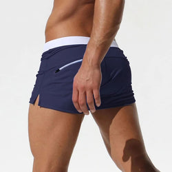 Dark blue low-waist surf trunks with white waistband and side pocket opening
