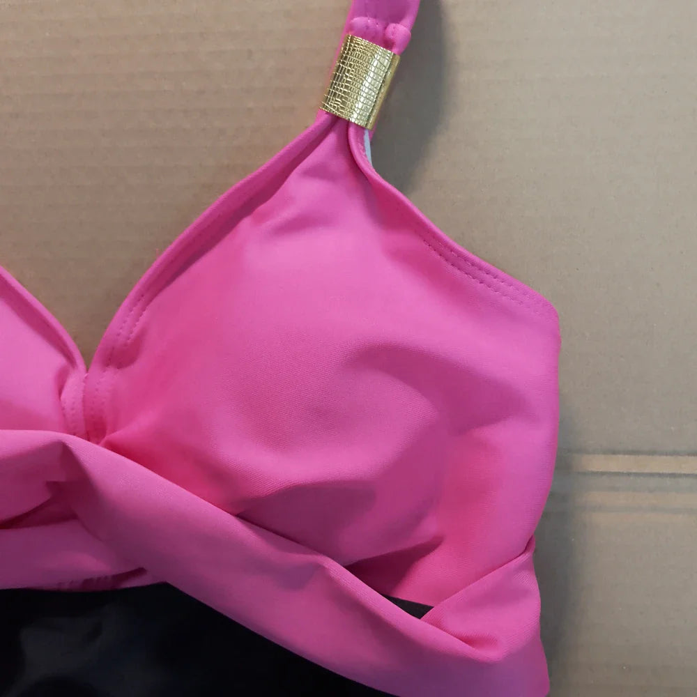 Pink tummy control swimdress one-piece with adjustable straps and a gold-toned textured strap clasp