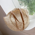 Beige straw round tote with tan leather double handles and open-weave sides