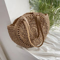 Brown-tan straw round tote with tan leather handles and woven cutout front