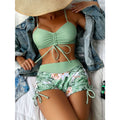 Mint green drawstring bikini top with high-waisted tropical floral shorts, green and white flowers.