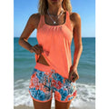 A vibrant coral sleeveless top with scoop neckline and ruching paired with a high-waisted two-piece swimsuit with print