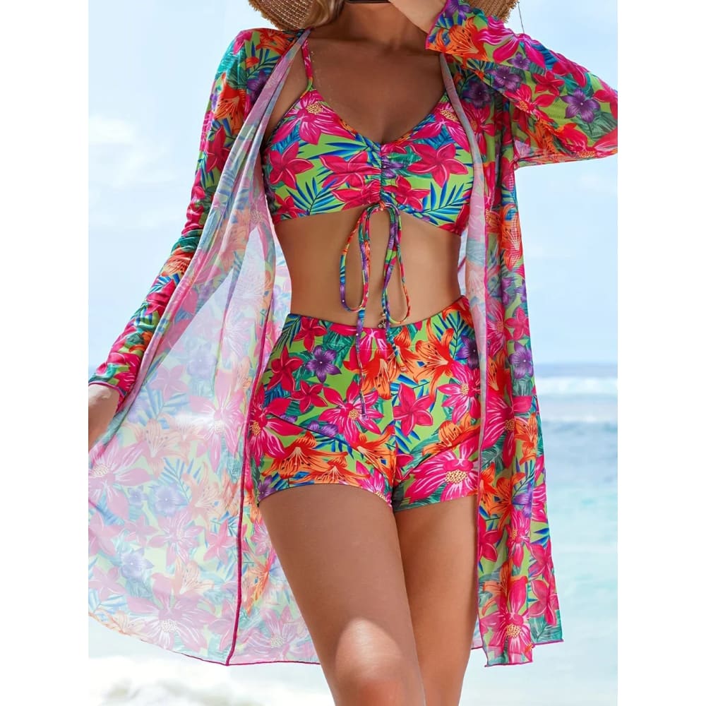 Vibrant tie-dye bikini set with high-waist shorts and matching long-sleeved cover-up in pink green and purple hues