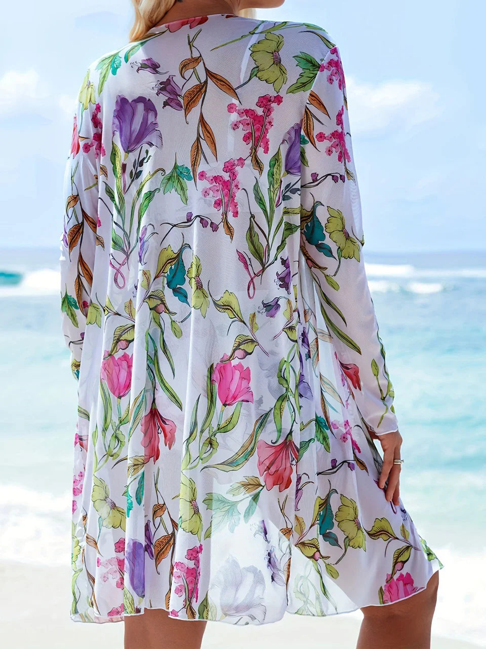A flowing white dress with vibrant pink purple and green floral pattern complementing a tie-dye bikini set design