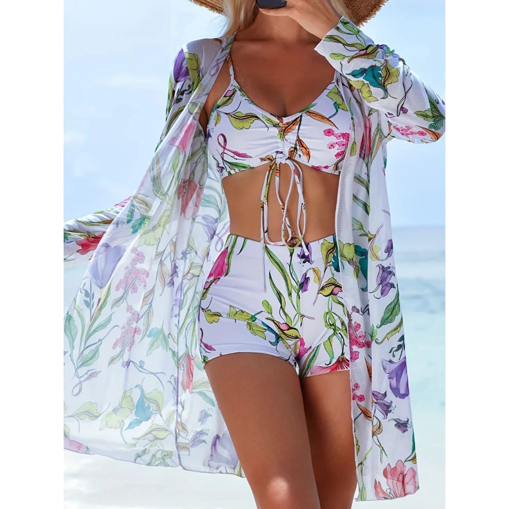 White floral print tie‑dye bikini set with colorful blossoms and matching sheer long‑sleeved cover‑up