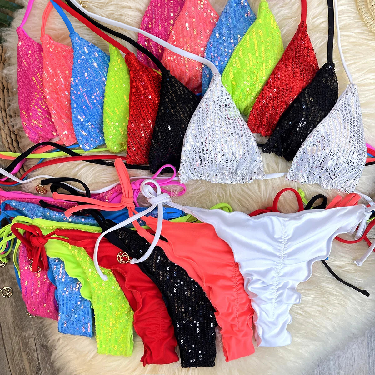 Eight color sequin triangle bikini sets with ruffle thong bottoms on white fur rug