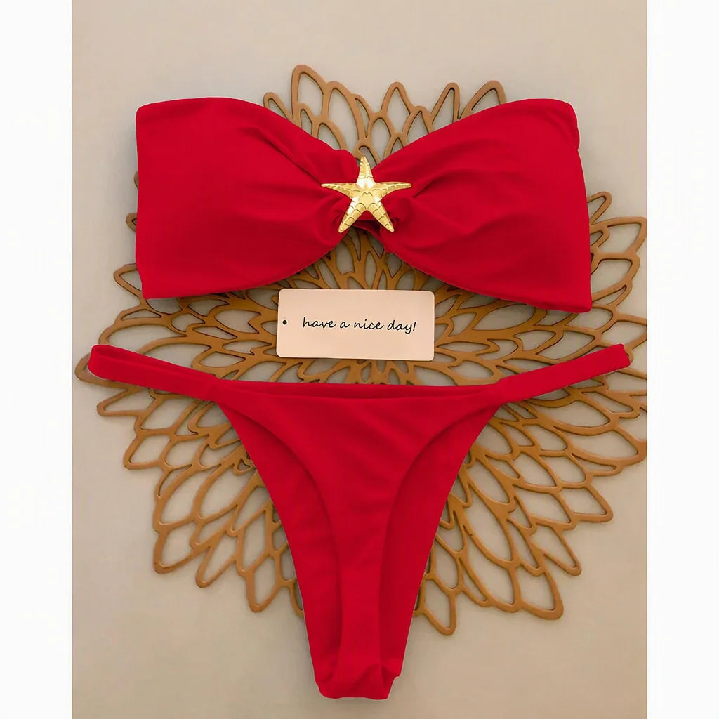 Red knot bandeau bikini top with gold starfish accent and micro thong bottom, flat lay