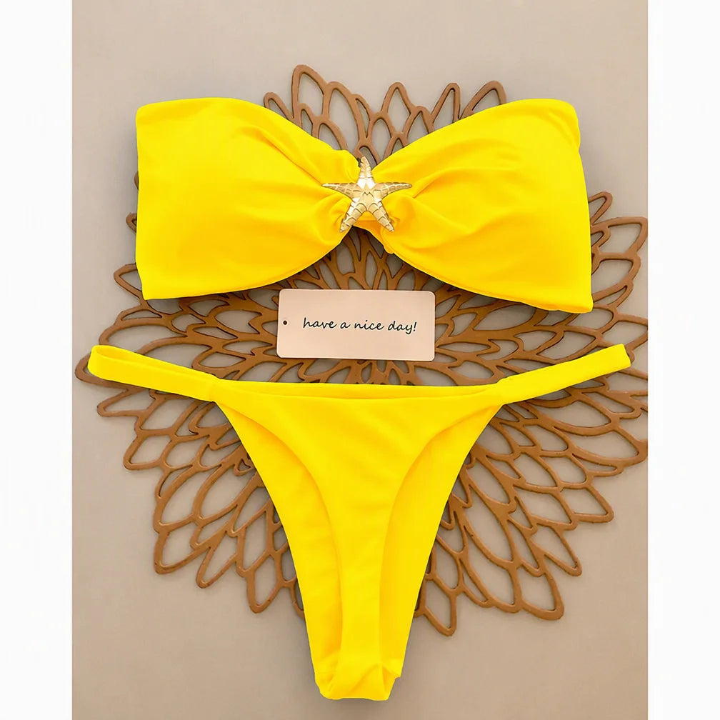 Yellow knot bandeau bikini set with gold starfish and micro thong bottom, flat lay